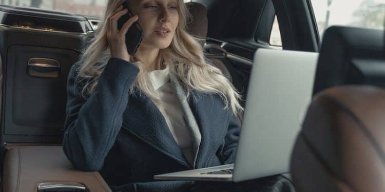 Woman in Gray Business Suit Sitting In A Luxurious Car