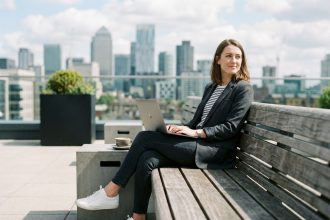 Femme en tenue décontractée assise sur une terrasse urbaine